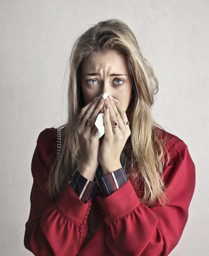 a woman crying with her itchy nose